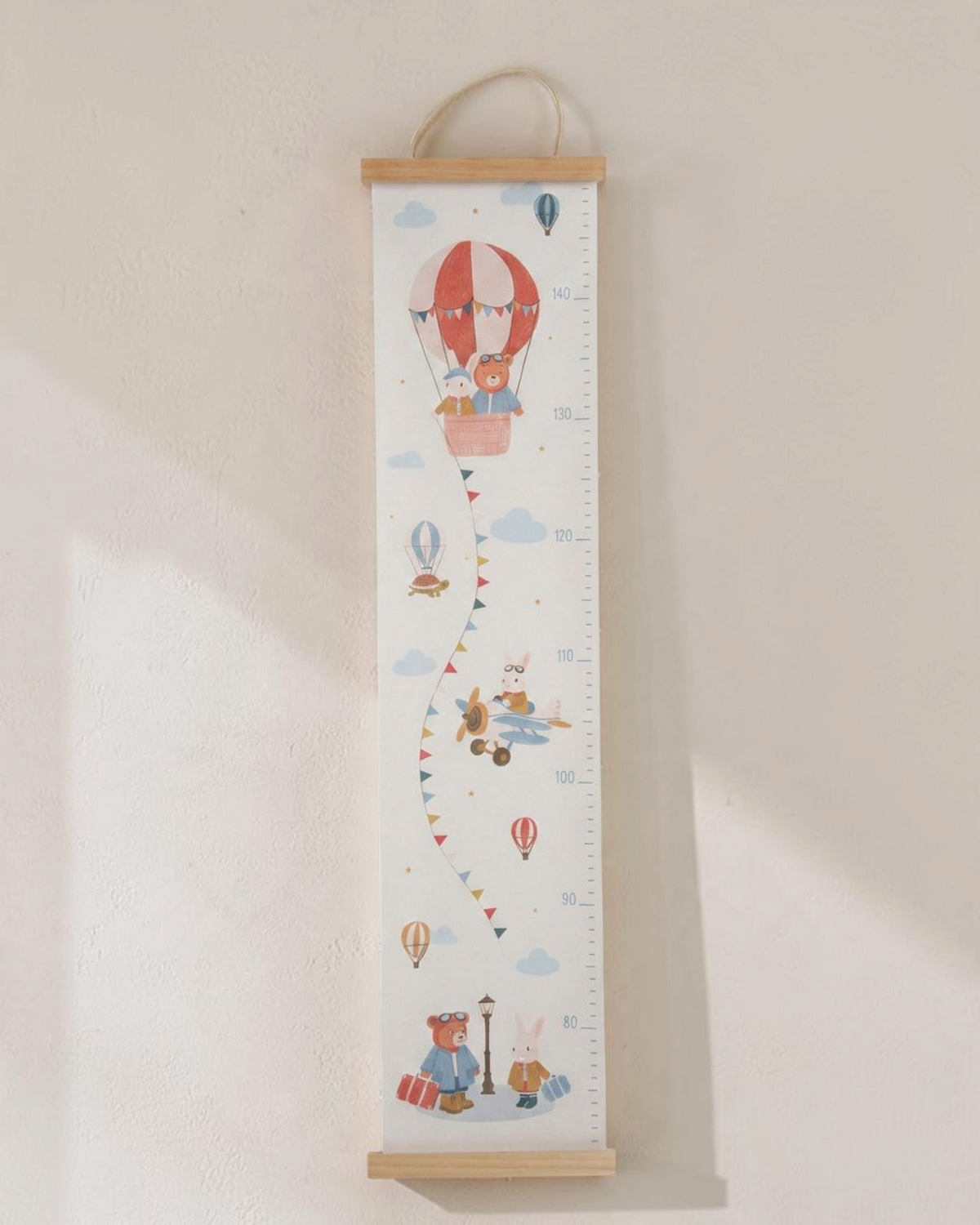 Sprall mätsticka för barn med motiv av luftballonger och djur i roströda och blå toner på vit bakgrund.
