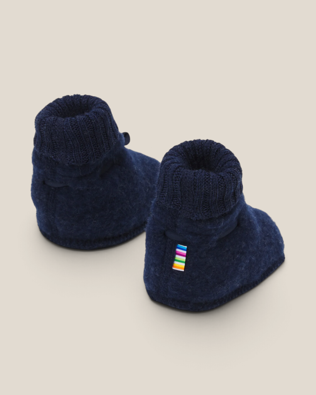 Sprall mörkblå ulltossor i mjuk merinoull med ribbad mudd och liten färgglad detalj för bebisar.