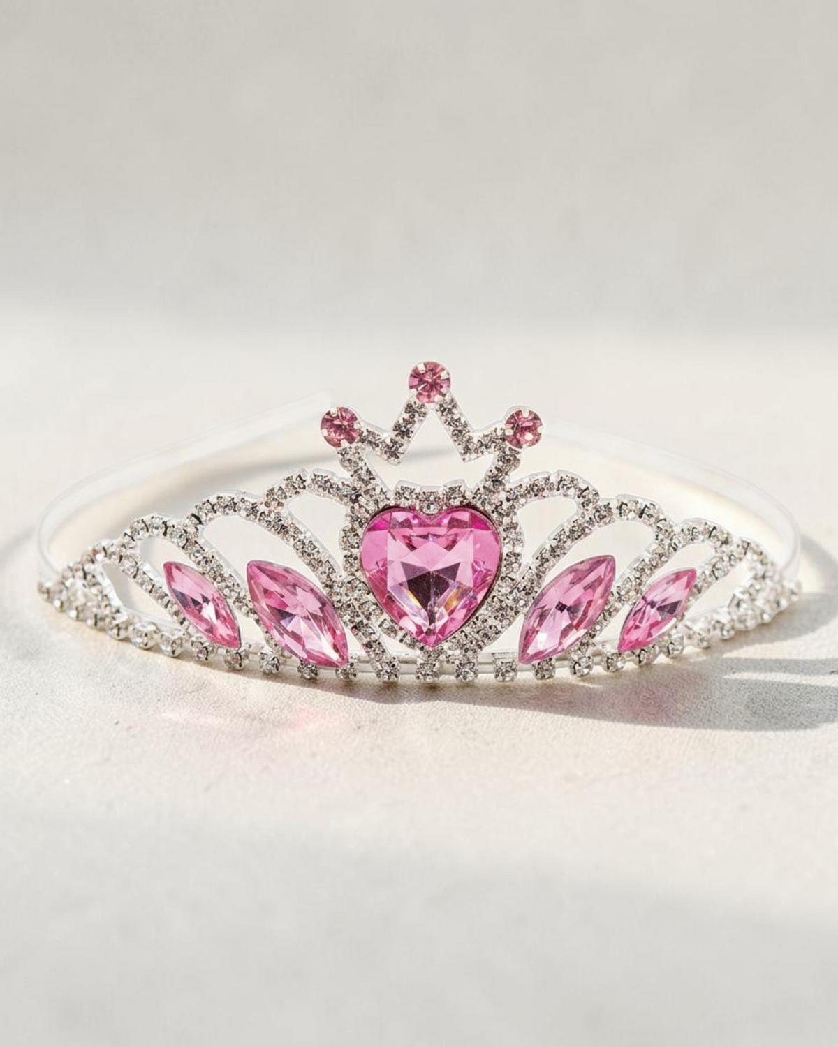 Sprall tiara i silverfärgad metall dekorerad med gnistrande rosa hjärtformade stenar för utklädnad.