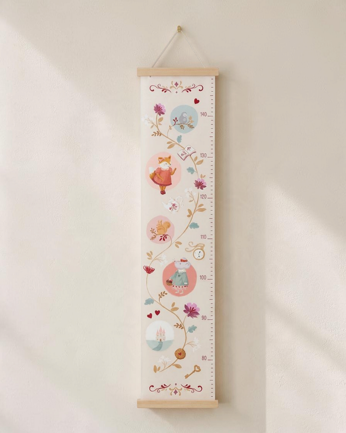 Sprall mätsticka för barn i rosa med sagolika skogsdjur, blommor och mätmarkeringar för väggupphängning.