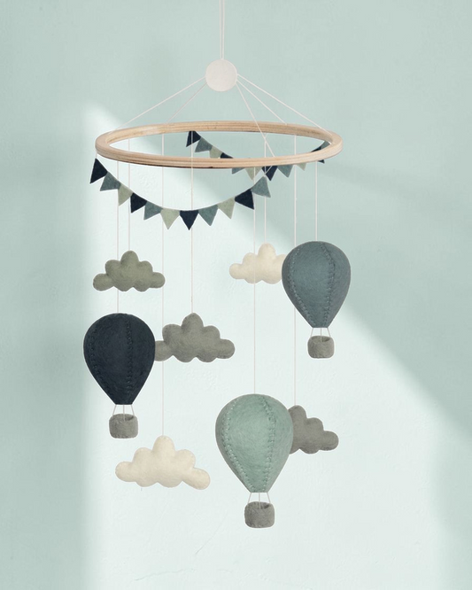 Sprall handgjord mobil i ull med luftballonger och moln i mjuka gröna och grå nyanser för barnrummet